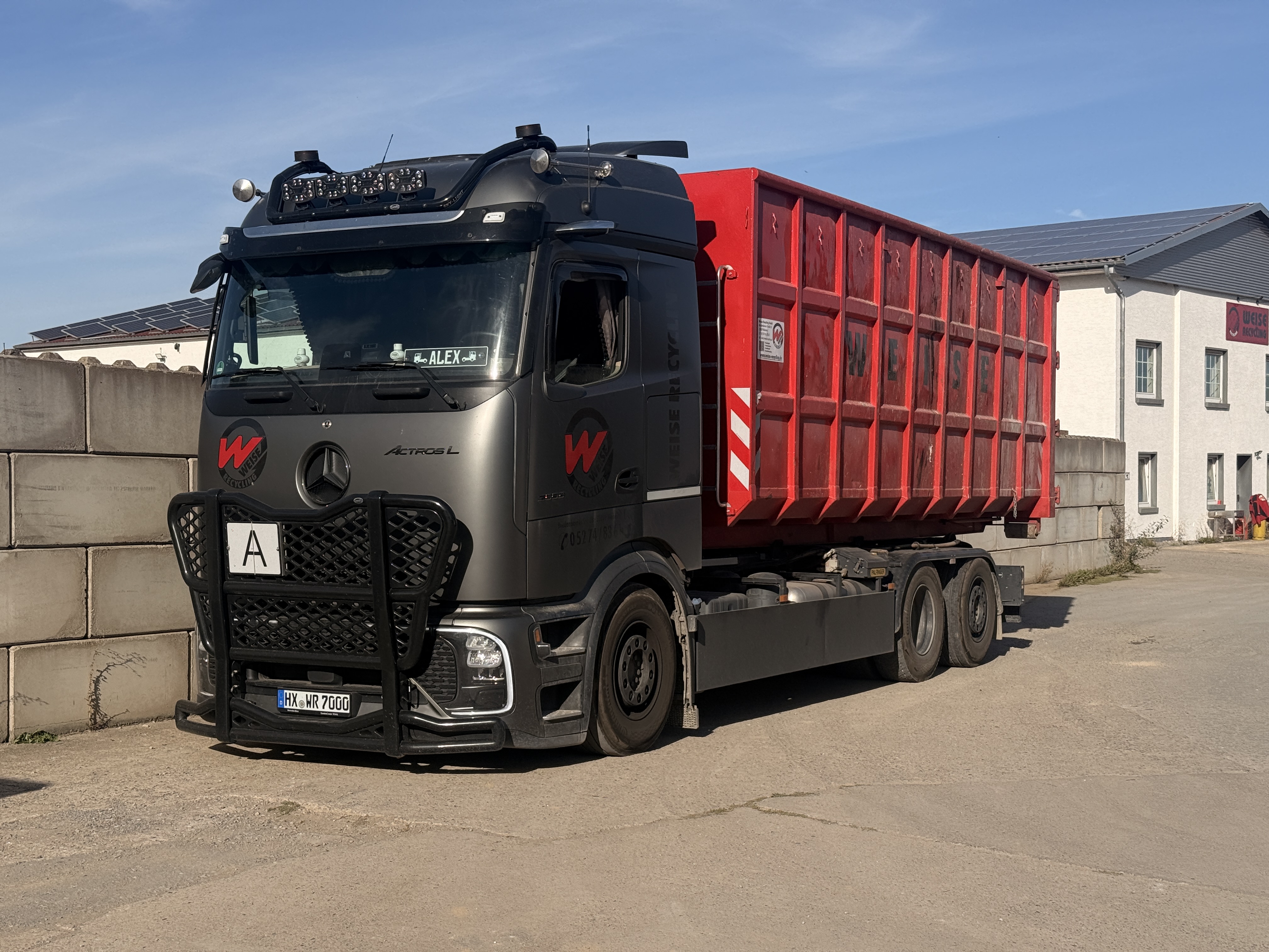 Weise-Lkw mit rotem Abrollcontainer