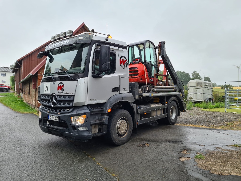 Weise-Lkw beim Transport eines Minibaggers